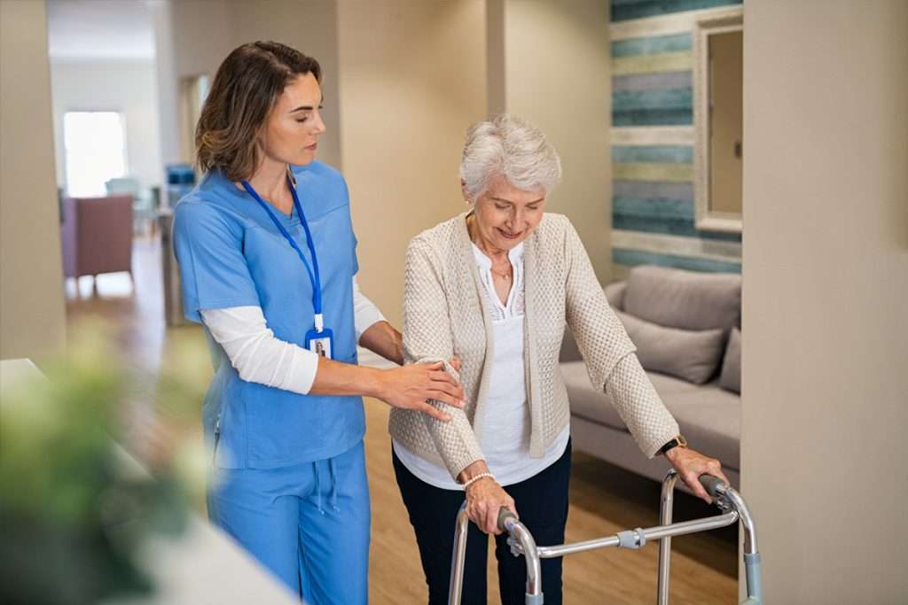 Female Caregiver Assisting Elderly Woman with Walker - Senior Caregiving Support